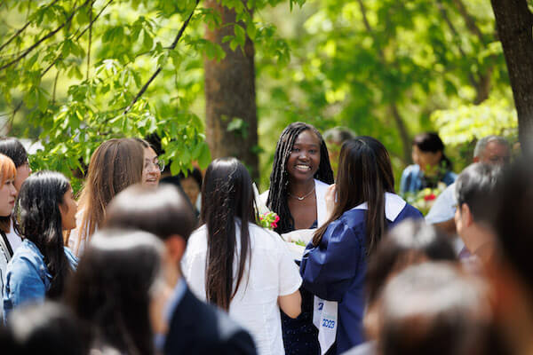 UWC ISAK Japan Class of 2023 student Fabi from Senegal, smiling in a crowd outside on campus after Graduation