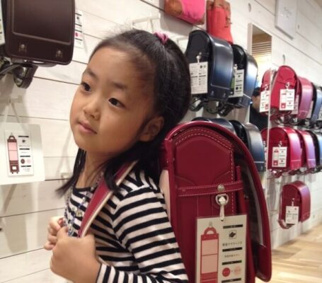 UWC ISAK Japan student Sayaka when she was little holding a heavy school bagpack to go to Japanese public school