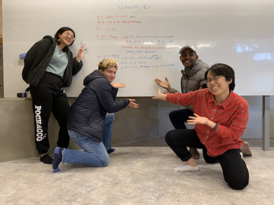 Four UWC ISAK Japan Sustainability Initiative students in front of a whiteboard presenting the activities of the day 