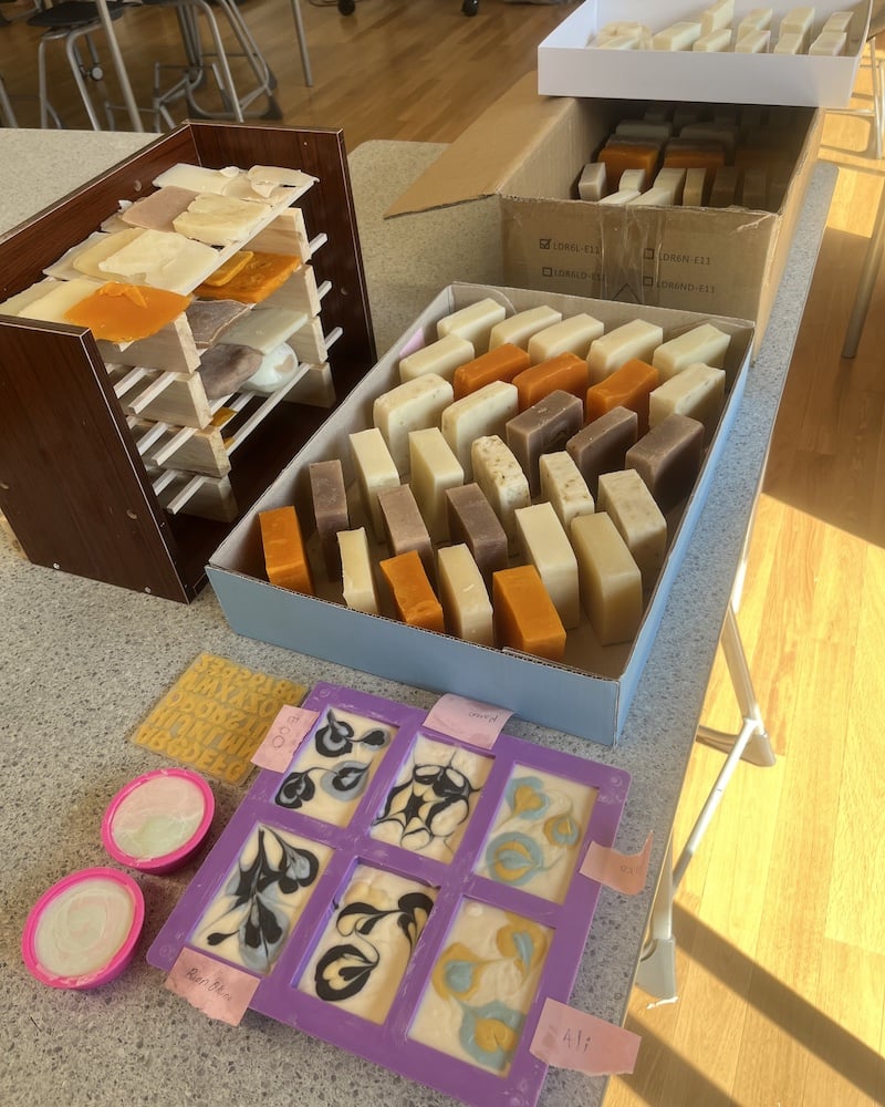 Handmade soap bars and intricate designs created by UWC ISAK Japan students during their EcoSoap project for Fall Project Week 2024. Various soap bars are displayed in boxes and molds, showcasing a range of colors and patterns.