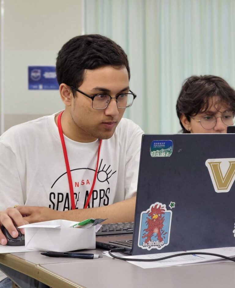 Focused UWC ISAK Japan student participates in the NASA Space App Challenge, working on innovative tech solutions at the laptop. The event highlights youth engagement in STEM, fostering creativity in space exploration and environmental technology. #NASAChallenge #UWCISAKJapan #STEMEducation