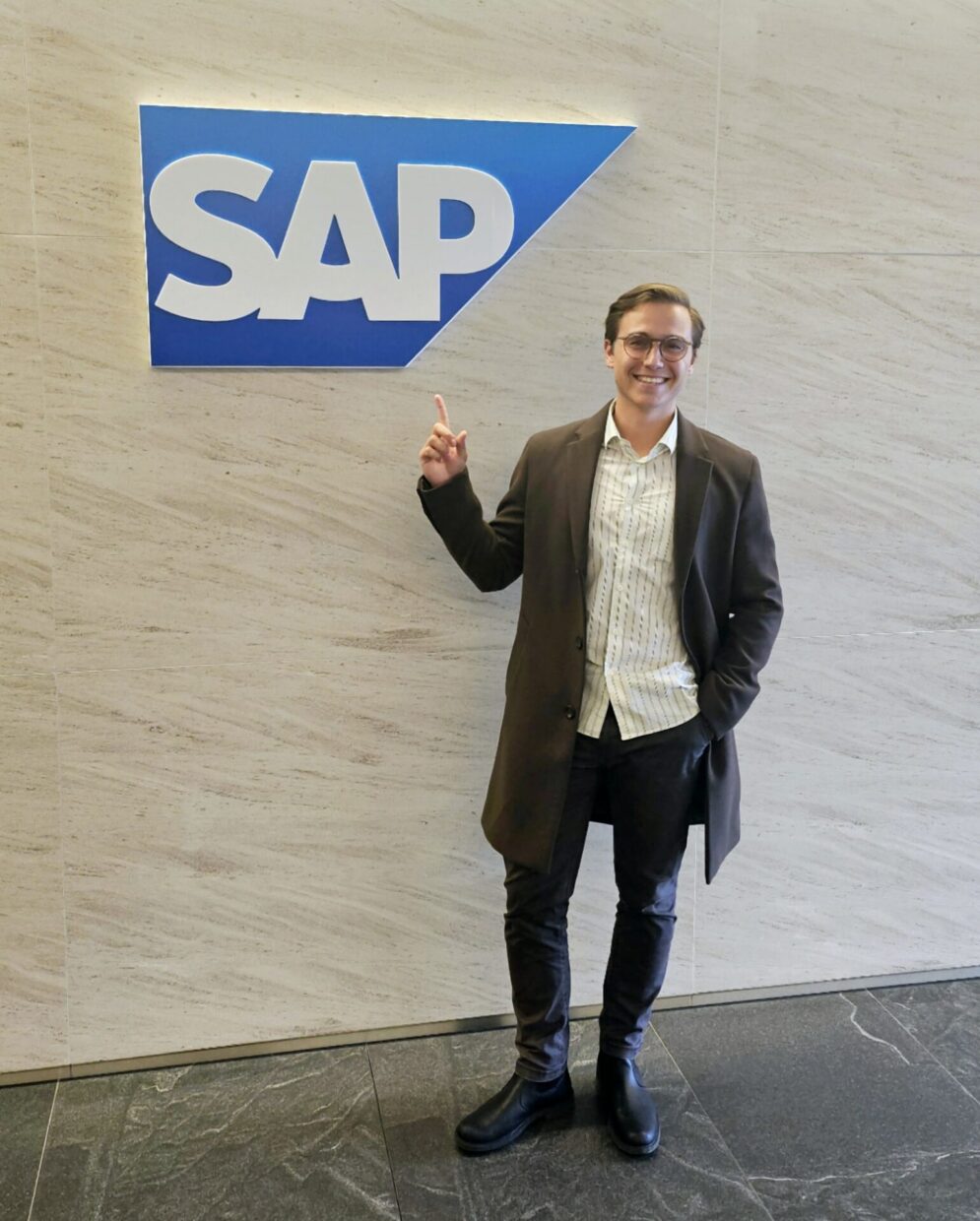 A vibrant portrait of Viktor, an ISAK alumnus, confidently smiling against a backdrop symbolizing global connectivity. The image reflects his journey from ISAK to becoming VP of Revenue Enablement at SAP, highlighting his dynamic leadership and international impact.